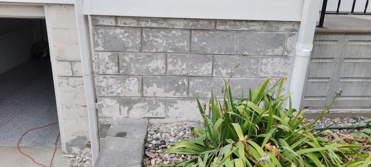 Weathered block foundation wall with failing surface on an Omaha home